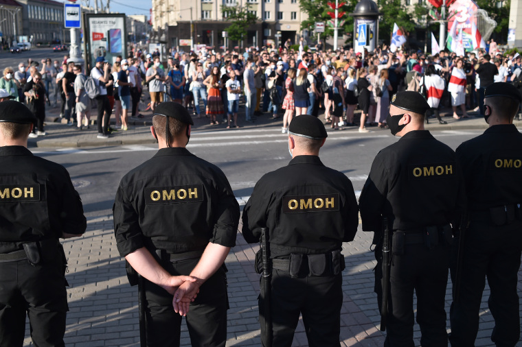 Riot police officers watch protesters in Minsk, Belarus, on June 19, 2020. Police detained more than a dozen journalists covering the protests, and charged three. (AFP/Sergei Gapon)