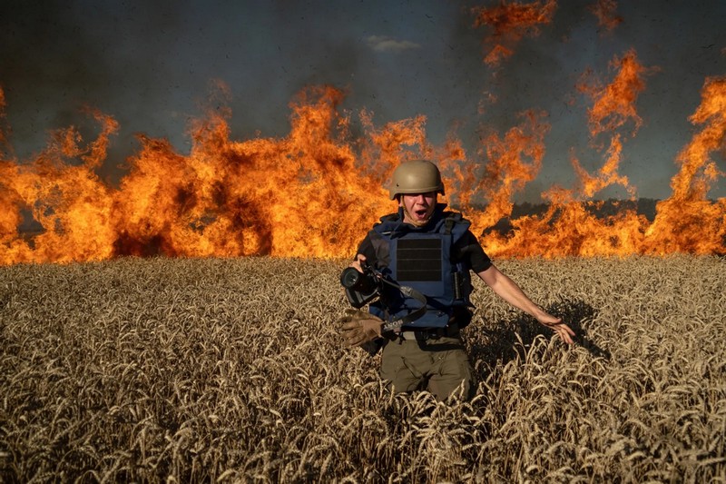 Украинский фоторепортер Евгений Малолетка в пшеничном поле, загоревшемся от попадания российского снаряда. Украина, Харьковская область, 29 июля 2022 года Mstyslav Chernov / AP / Scanpix / LETA