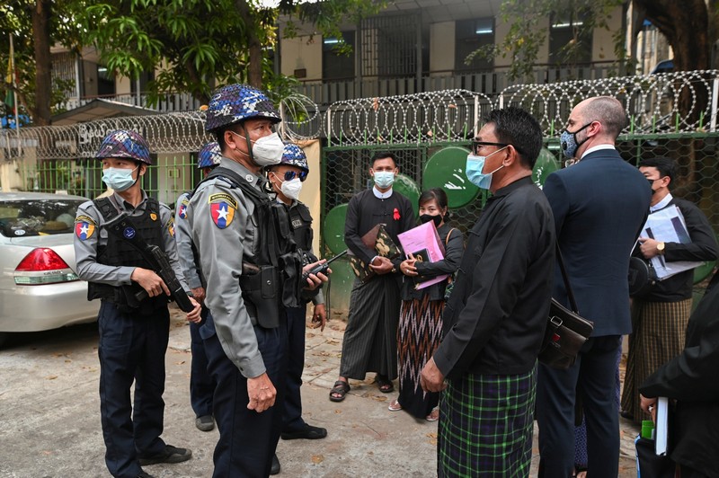 Police officers and lawyers wait outside a Yangon court for a scheduled March 12, 2021, hearing for a group of journalists detained during protests against Myanmar’s military coup. (Reuters/Stringer)