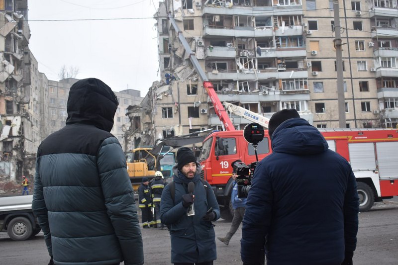 Журналісты працуюць каля разбуранага расійскай ракетай жылога будынку. Днепр, студзень 2023 года. Фота: Алесь Мінаў