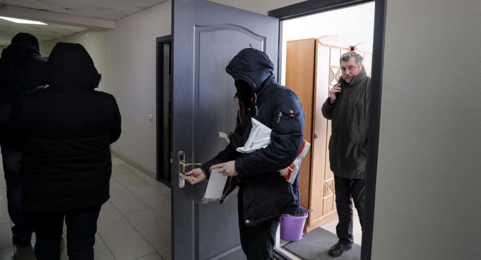 Сотрудники милиции выносят документы и компьютеры из офиса Белорусской ассоциации журналистов в Минске, Беларусь, 16 февраля 2021 (Shutterstock)