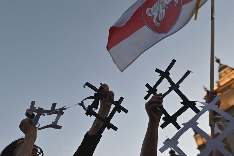Протестующие c бумажными тюремными решетками, символизирующими политических заключенных и отсутствие свободы в Беларуси, Краков, Польша, 9 августа 2022 года © 2022 Artur Widak/NurPhoto via AP
